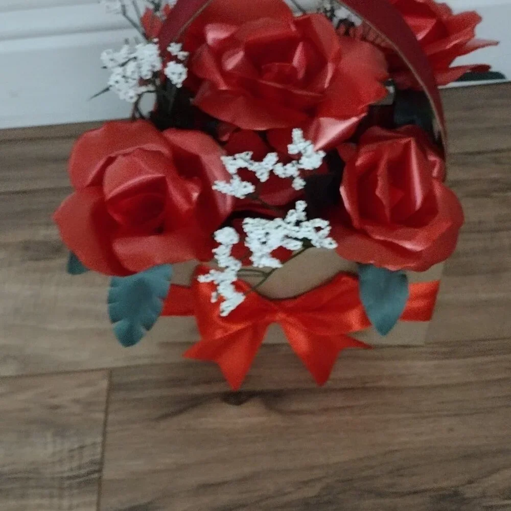 Handmade floral arrangement with plastic ribbon roses.